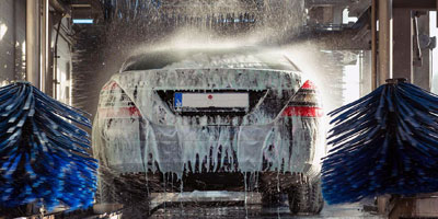A soapy car inside a car washer